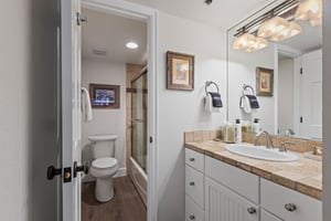 The en suite bathroom has a single sink vanity and bathtub and shower combination.