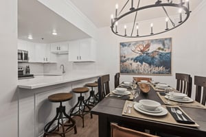 The dining table has 6 chairs, beautiful chandelier and moose artwork.