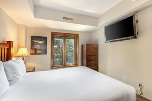 One of the bedrooms offers a queensize bed and wood furniture.