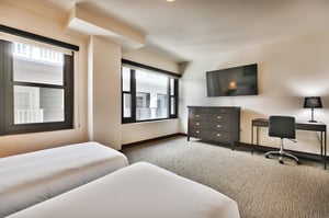 Guest bedroom with wall mounted flat screen TV and dedicated work or study desk