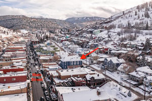 Blue Church Lodge exterior with the snowy Historic Main Street in Park City and Park City Mountain behind.