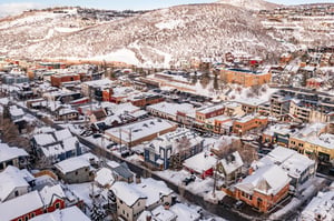 Blue Church Lodge exterior with the snowy Historic Main Street in Park City and Park City Mountain behind.