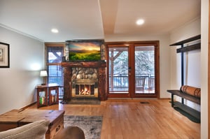 Glass doors for bright living area, river stone fireplace