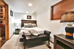 Queen bed with wooden headboard and leather bedroom bench