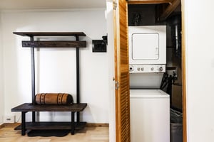 Entryway with convenient wooden bench and equipment rack and stacked washerdryer