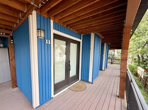 The vibrant blue exterior and welcoming doubledoor entry of Woodside 11.