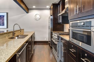 The wellequipped kitchen has dark wood cabinets and stainless steel appliances.