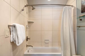The bathroom with a combination shower and bathtub.