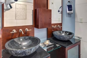 The en suite bathroom has a two sink modern style vanity.