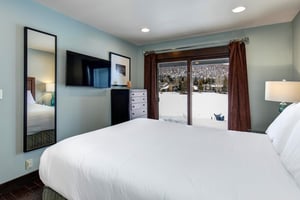 The bedroom with a queen size bed and flat screen TV.