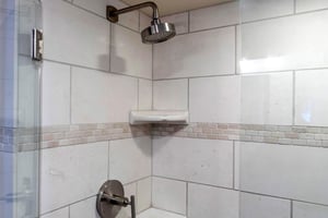 The bathroom with a walkin tiled shower.