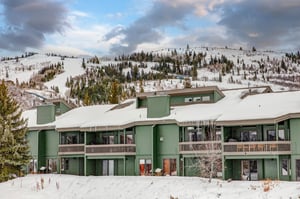 The exterior of the property with a snowy mountain behind it.