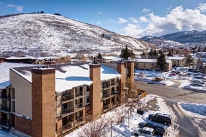Multistory property buildings nestled in a snowy mountain valley with scenic winter landscapes and convenient parking areas.