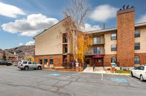 Property exterior featuring brick and stucco construction with mountain backdrop and convenient parking access.