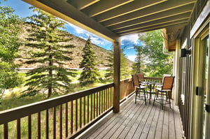 Main level private wood deck and covered patio with bistro table and chairs