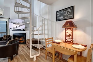 Settle into your cozy mountain retreat with rustic charm  dine by lamplight at your intimate wooden table while the fireplace creates the perfect aprèsski ambiance.