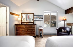 Your cozy bedroom features rustic wood furnishings, comfortable seating, and warm lighting for a relaxing mountain retreat experience.