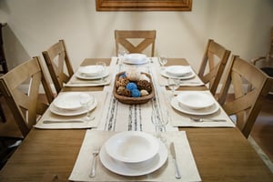 Gather around this beautifully set dining table for six, where every meal becomes a special occasion. The elegant place settings and warm wood tones create the perfect backdrop for your shared moments