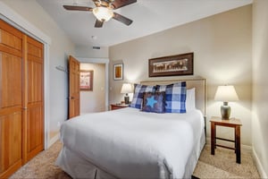Sink into crisp white linens in your cozy bedroom, complete with westerninspired decor, warm lighting, and a gentle ceiling fan for your perfect nights rest.