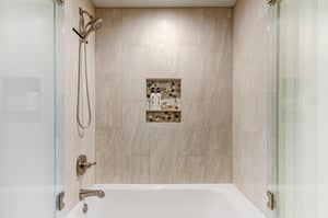 Your private bathroom features a sleek tubshower combo with a modern handheld showerhead. Elegant tile walls and a builtin niche provide both style and convenience for your stay.