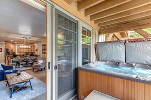 Step onto your private covered deck where a bubbling hot tub awaits beneath natural wood beams. Inside, the openplan living and kitchen space invites you to gather and unwind.