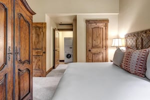 Relax in this charming bedroom with rustic wood details and convenient insuite laundry access for your mountain getaway.