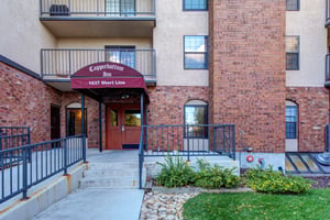 Welcome to Copperbottom Inn, your charming brick retreat with classic architecture and inviting entrance awaiting your arrival.