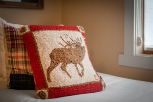 Decorative moose accent pillow adds a cozy mountain touch to the bedroom decor