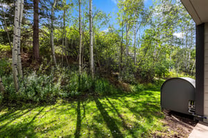 Wooded outdoor setting with mature aspen trees beside the Snow Flower condo