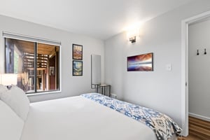 The bedroom offers a king size bed and a flat screen TV mounted on the wall.