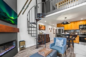 The well styled living room with a spiraled staircase.