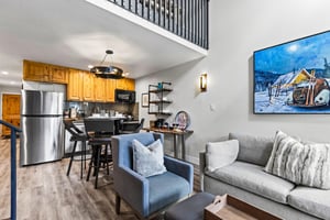 The living room has a light grey couch and two club chairs.