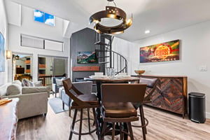 The dining table with seating for four guests and a artistic spiral chandelier.