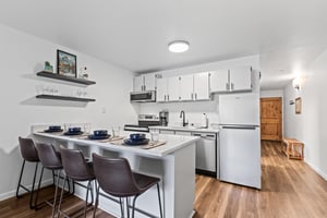 The updated kitchen has stainless steel appliances and light grey cabinets.