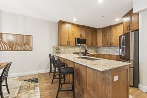 The wellequipped kitchen has beautiful wood cabinets and granite counters.