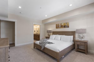 Main bedroom with king bed, bedside tables, recessed lighting and open access to the private ensuite bathroom.