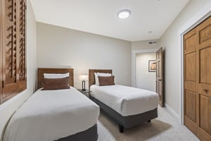 Third bedroom with two twin beds, matching wood headboards and bedside table, with beds convertible to a king.