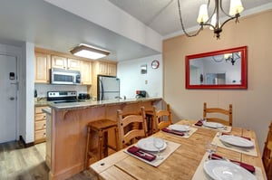 Dining area with wood table, breakfast bar seating and open access to the fully equipped kitchen.