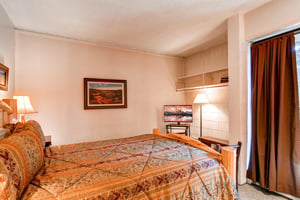 The guest bedroom with a king bed and TV.