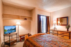 The guest bedroom with a king bed and TV.