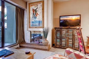 The living room features a cozy gas fireplace, large screen TV, and comfortable furniture.