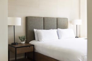 King bed in the main bedroom with wooden side tables and tableside lamps.