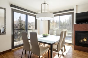 Square dining table with mountain views through the stunning window walls.