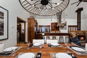 The dining area has an inviting table set for six guests with a chandelier for perfect lighting.