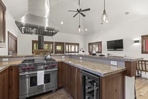 Town Lift Chalets kitchen with breakfast bar, stainless steel Wolf range, stainless hood vent, and wine fridge.