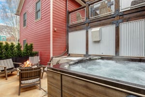 The heated patio offers a hot tub, fire table with seating for four, and BBQ gas grill.