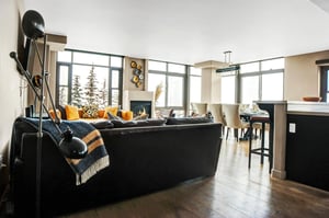 Open living room with comfortable seating, wood floors and large windows overlooking the surrounding mountains.
