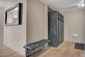 Entryway with builtin storage lockers, upholstered bench and wood flooring for convenient gear storage.