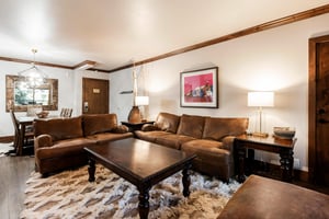 Comfortable living room with leather sectional, warm lighting and rustic mountaininspired accents.