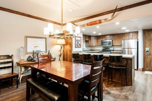 Unit 229 dining area with wood table, seating for six and open access to the kitchen.